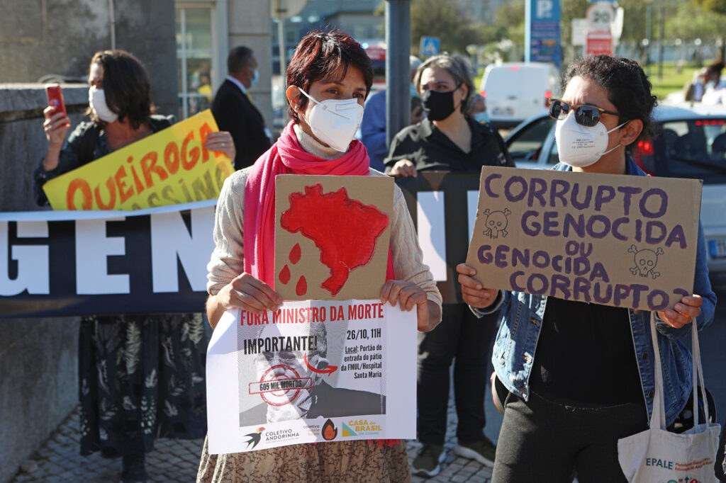 Cidadãos brasileiros protestam contra uma conferência do ministro da Saúde do Brasil, Marcelo Queiroga (ausente da foto), sobre o tema "As ações do Brasil no enfrentamento da covid-19", em frente à Faculdade de Medicina da Universidade de Lisboa, em Lisboa, 26 de outubro de 2021. Marcelo Queiroga é um dos visados pela investigação da comissão parlamentar de inquérito que ao longo dos últimos meses avaliou falhas e omissões na ação do Governo brasileiro na gestão da pandemia de covid-19. ANTÓNIO PEDRO SANTOS/LUSA