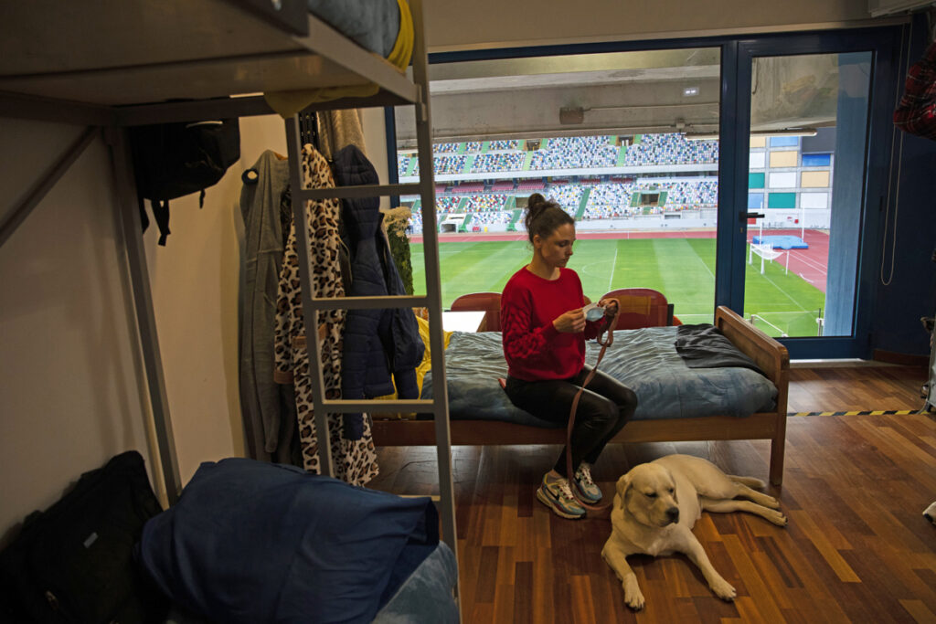 Olga Postolenko, refugiada da Ucrânia, está num quarto adaptado de um camarote do Estádio Dr. Magalhães Pessoa, em Leiria. Entrar no piso dos camarotes do Estádio de Leiria faz esquecer que estamos numa infraestrutura desportiva. À saída dos elevadores ouvem-se os risos e as brincadeiras das crianças. Há uma televisão a transmitir desenhos animados e um quadro a giz, onde portugueses filhos de ucranianos ajudam a integrar os novos amigos. PAULO CUNHA/LUSA